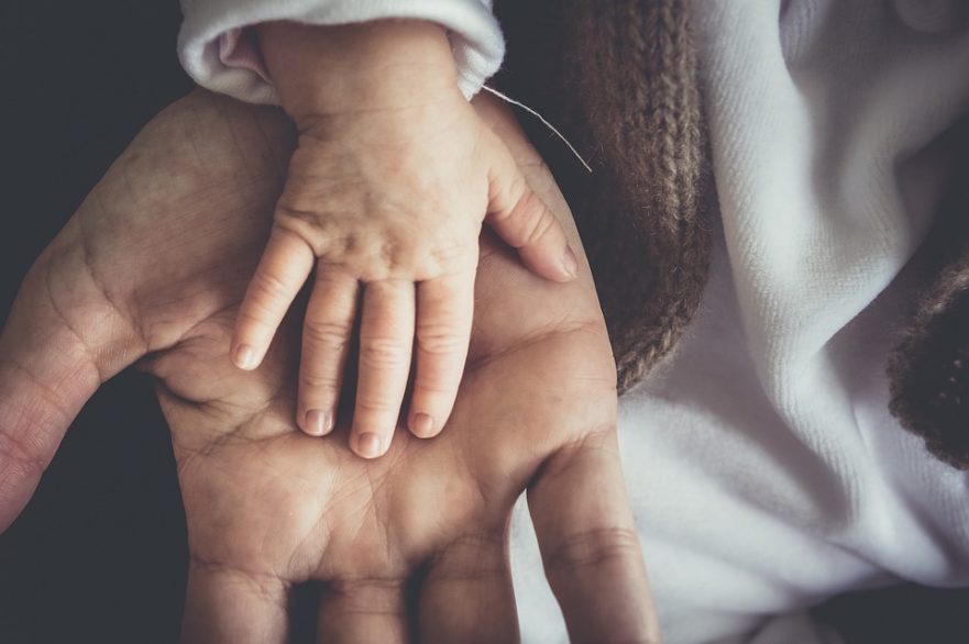 Kinderhand liegt in erwachsener Hand